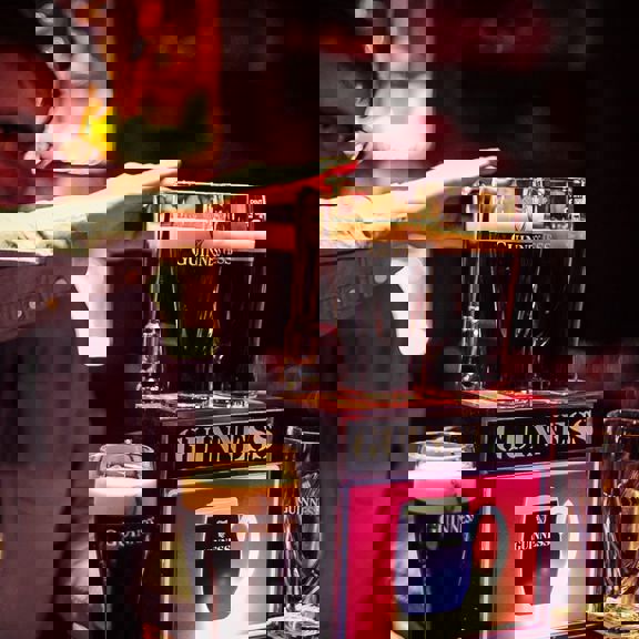 Man pouring a Guinness at Gibney's bar in Shoreditch